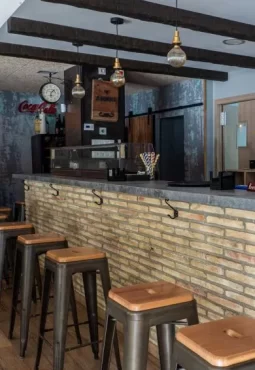 Imagen de la barra del bar con sillas altas en el bar restaurante en Zaragoza el ibón de Miralbueno